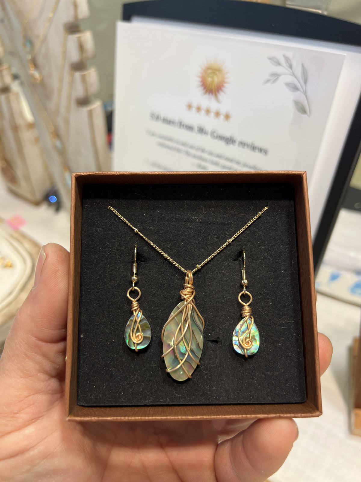 Handmade abalone shell gift set: gold wire-wrapped marquise pendant on a gold satellite chain with matching abalone teardrop earrings in a gift box